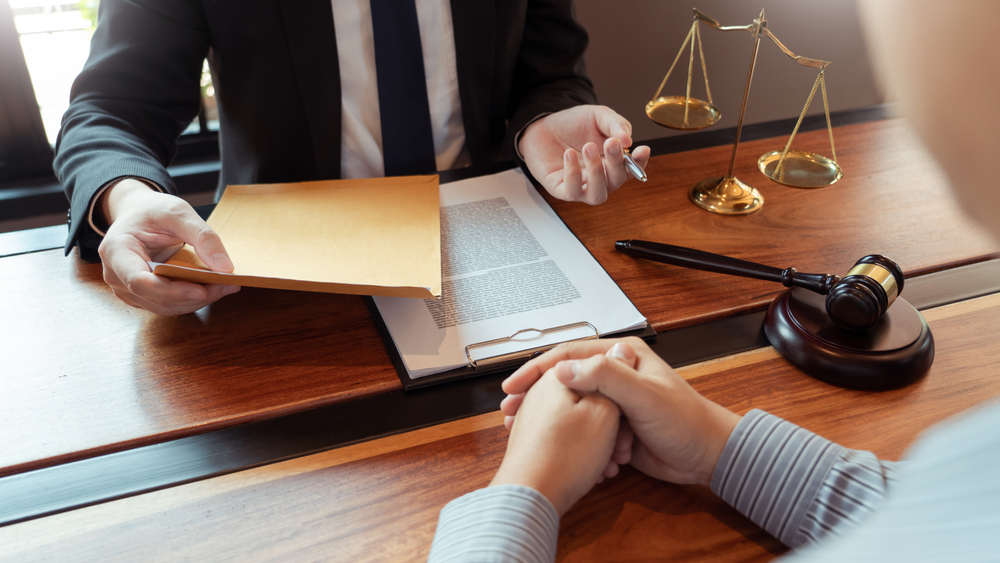 Lawyer sits at desk with client and determines if they can get early release from probation in Texas.