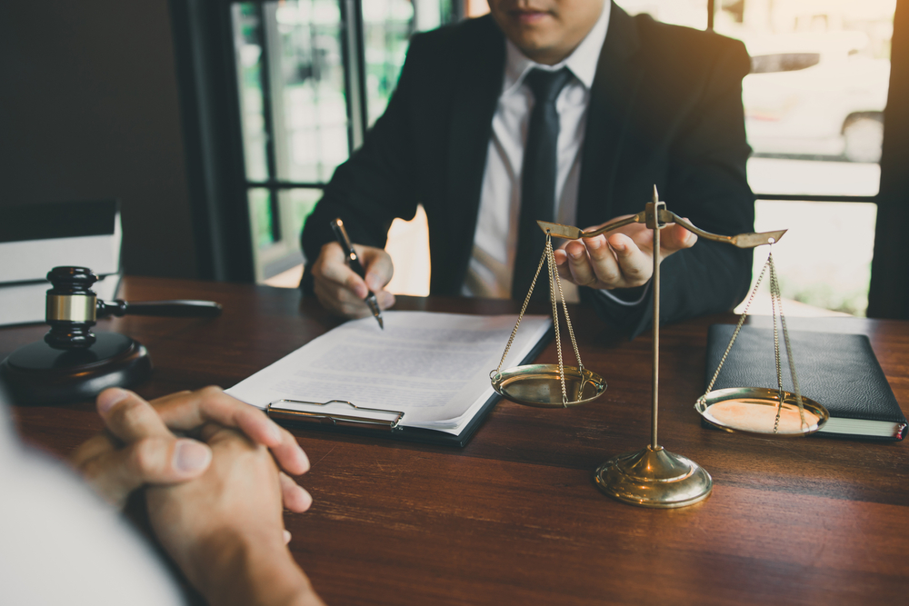 Attorney sits at desk with client and explains potential possession drug law loopholes in Texas.